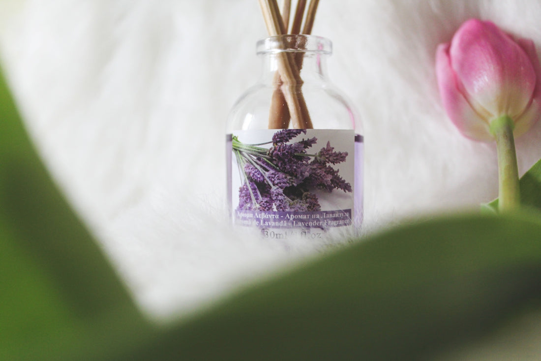 a bottle filled with flowers sitting on top of a white blanket