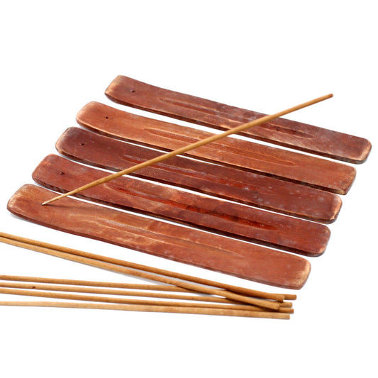 Wooden incense holders with several incense sticks on a white background