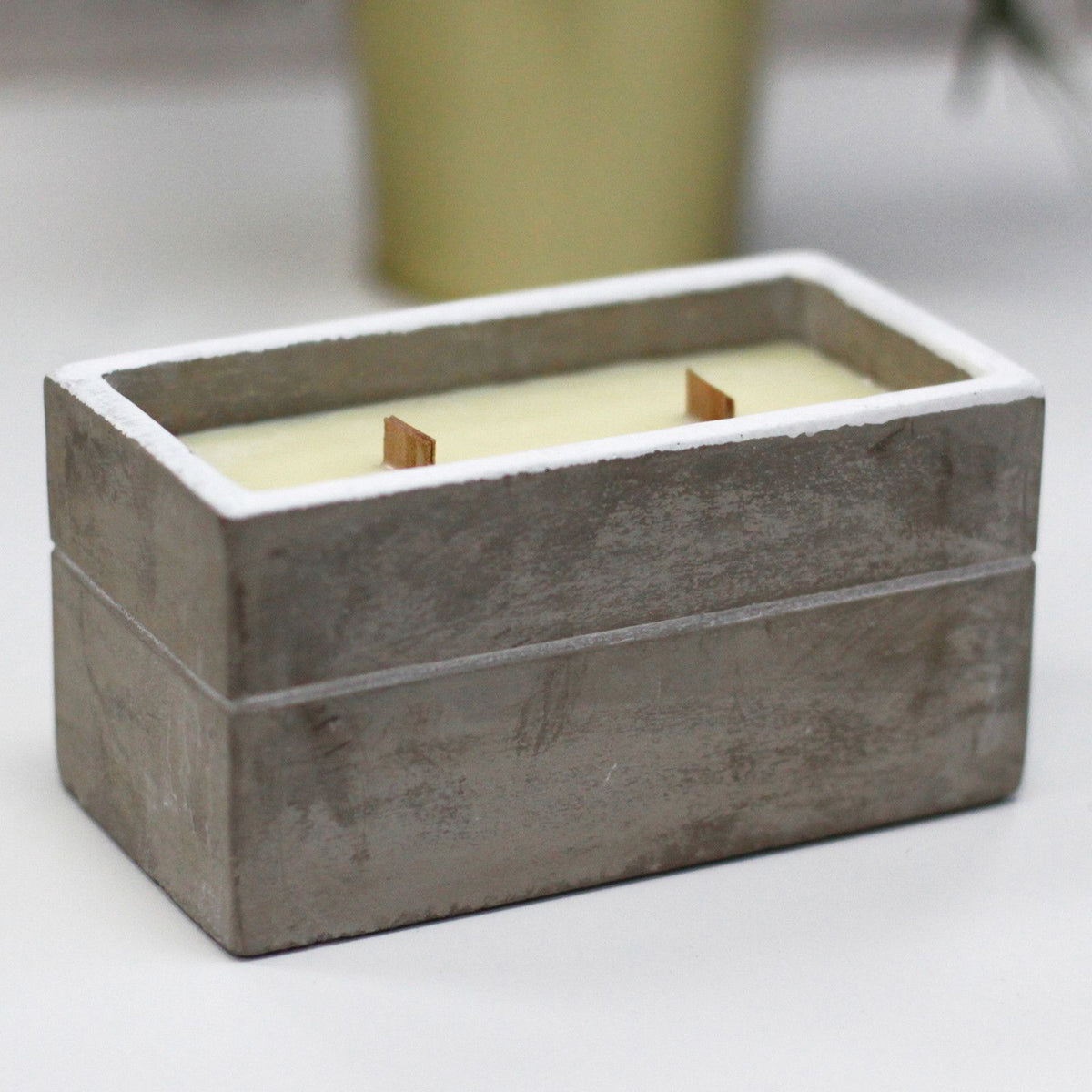 Rectangular concrete candle holder with two wooden wicks and creamy wax