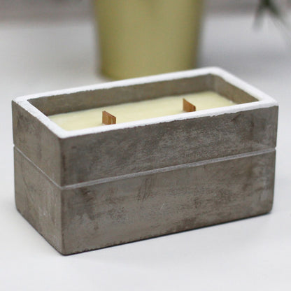 Rectangular concrete candle holder with two wooden wicks and creamy wax