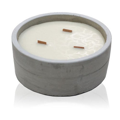 White scented candle with three wooden wicks in a grey concrete container