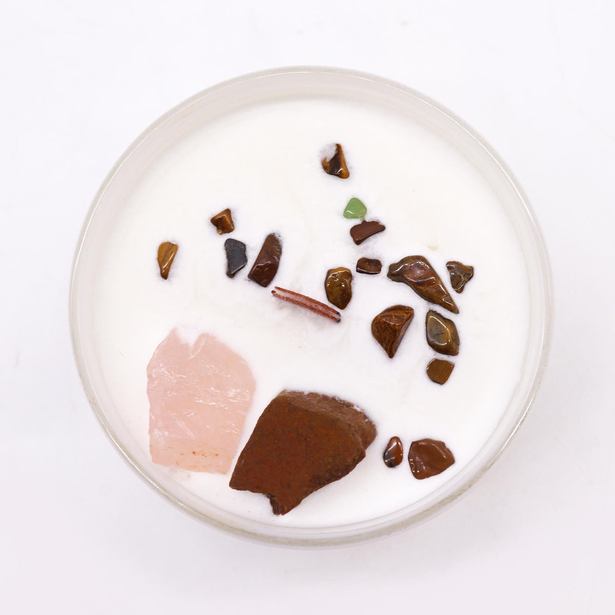 Top view of a white scented candle with decorative crystals and gemstones