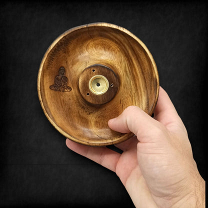 Wooden incense burner bowl with Buddha engraving and metal center held by a hand