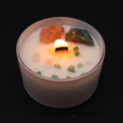 Lit white soy candle with a wooden wick, decorated with rose quartz and aventurine crystals